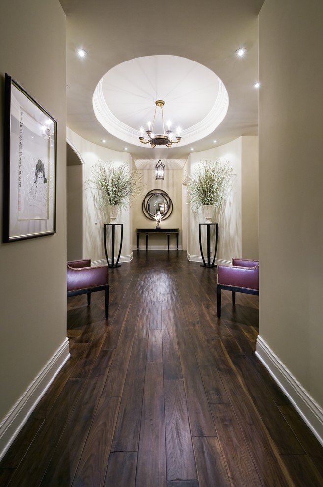 This is an example of a contemporary hallway in Los Angeles with beige walls, dark hardwood floors and brown floor.