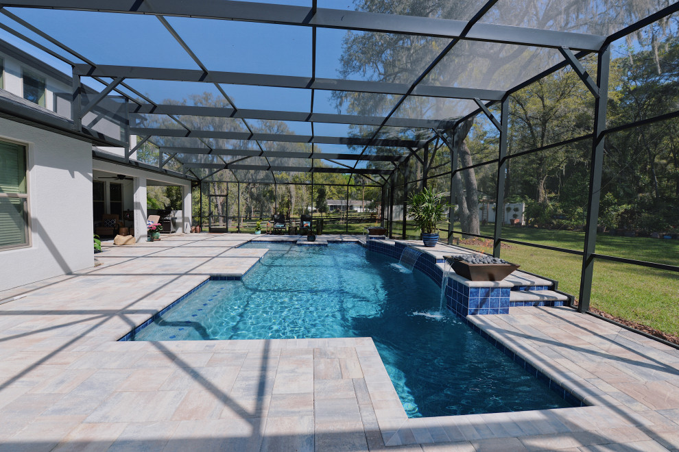 This is an example of a mid-sized country backyard rectangular pool in Orlando with brick pavers.