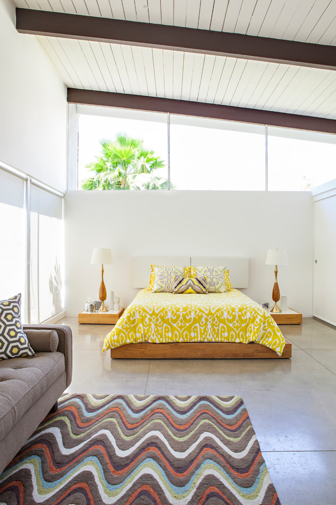 Inspiration for a midcentury bedroom in Other with white walls, concrete floors and grey floor.