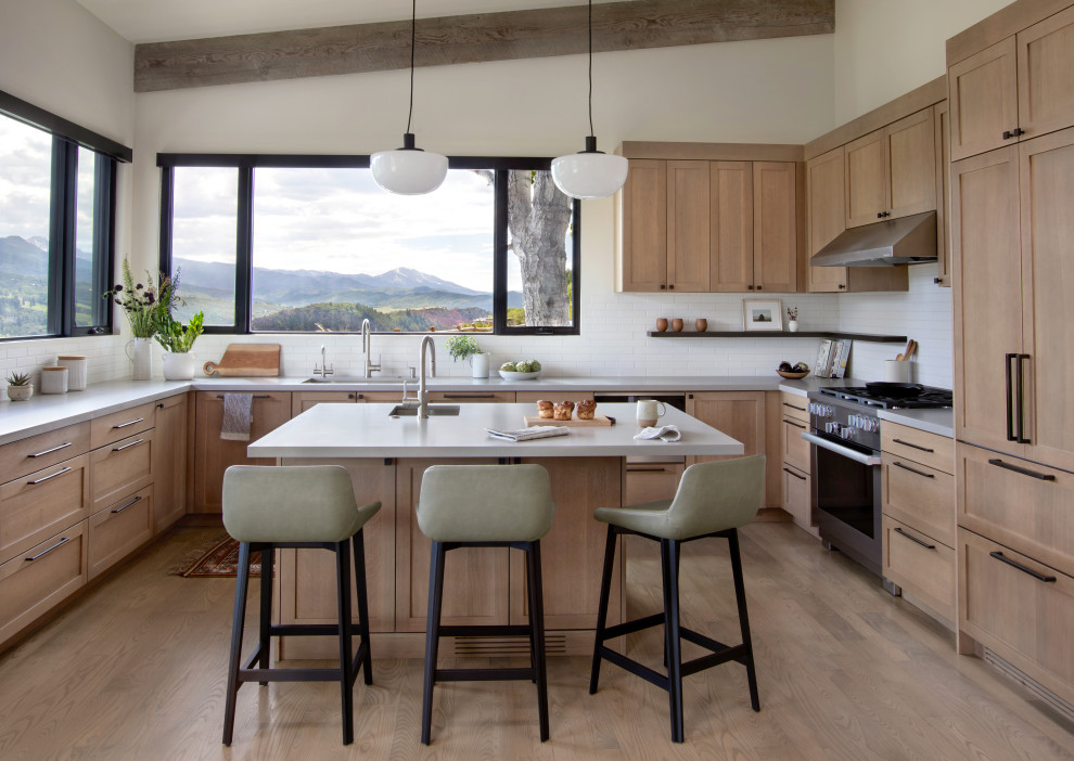 Inspiration for a mid-sized rustic u-shaped medium tone wood floor enclosed kitchen remodel in Denver with an undermount sink, shaker cabinets, medium tone wood cabinets, quartz countertops, white backsplash, subway tile backsplash, stainless steel appliances and an island