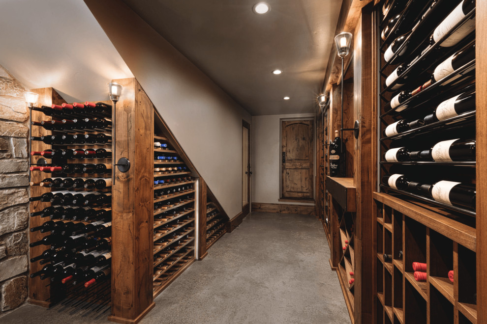 This is an example of a mid-sized mediterranean wine cellar in Portland with concrete floors, diamond bins and grey floor.
