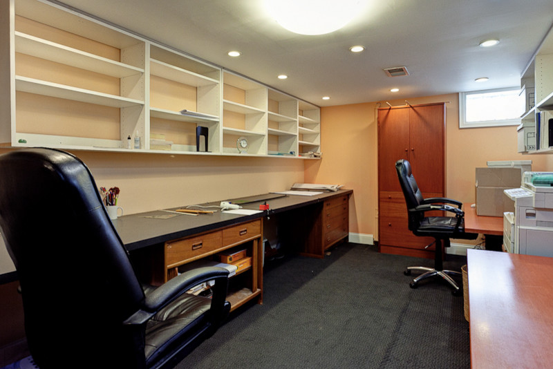 Mid-sized contemporary study room in Columbus with beige walls, carpet and a built-in desk.