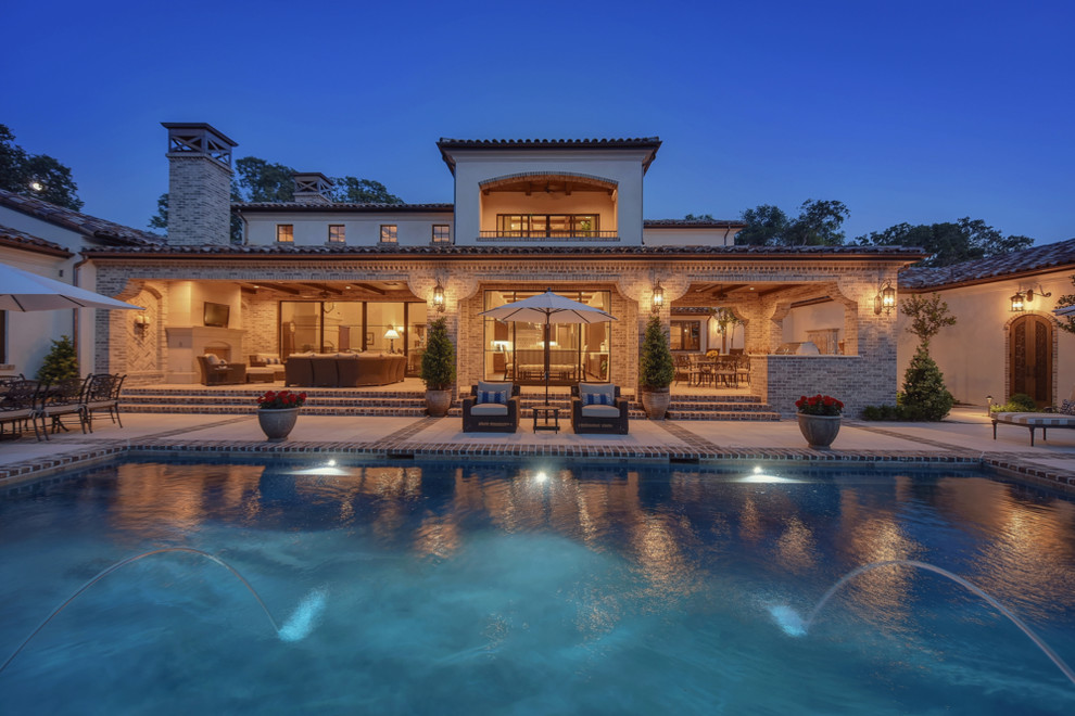 Inspiration for an expansive mediterranean backyard rectangular pool in Sacramento with a water feature and tile.