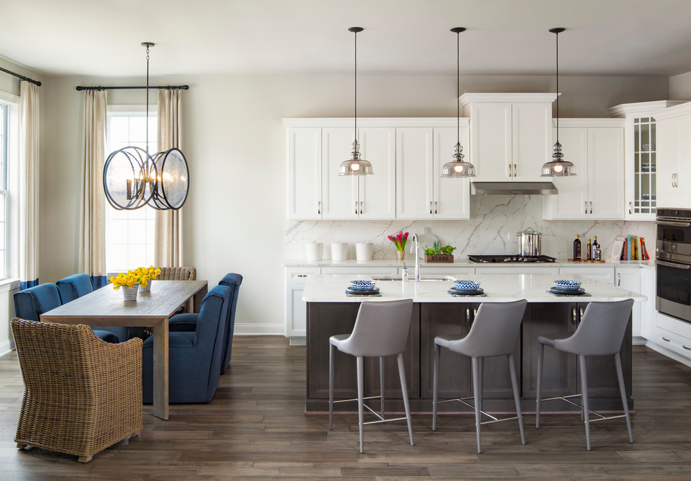 Transitional l-shaped dark wood floor eat-in kitchen photo in DC Metro with an undermount sink, recessed-panel cabinets, white cabinets, white backsplash, stone slab backsplash, an island and white countertops