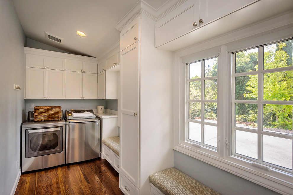 Photo of a mid-sized traditional dedicated laundry room in San Francisco with shaker cabinets, marble benchtops, grey walls, medium hardwood floors, a side-by-side washer and dryer and white cabinets.