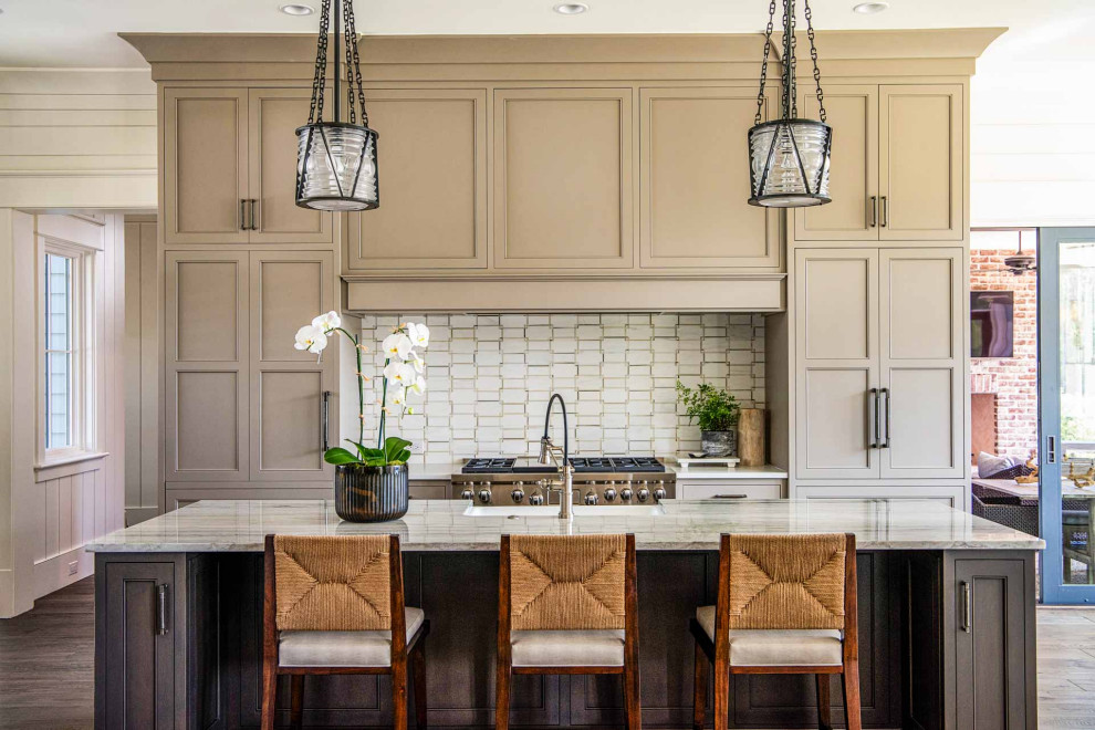 Dark wood floor and brown floor eat-in kitchen photo with a farmhouse sink, beaded inset cabinets, beige cabinets, marble countertops, marble backsplash, stainless steel appliances and an island