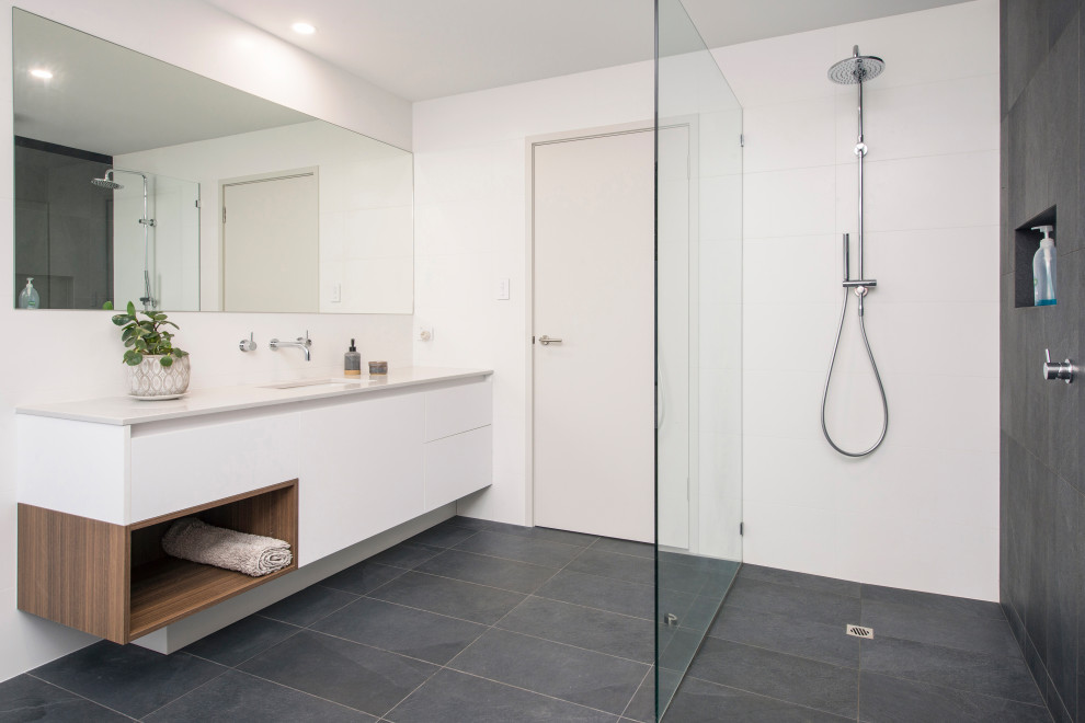 Photo of a contemporary bathroom in Perth with flat-panel cabinets, white cabinets, a curbless shower, gray tile, white tile, white walls, an undermount sink, grey floor, an open shower, white benchtops, a single vanity and a floating vanity.