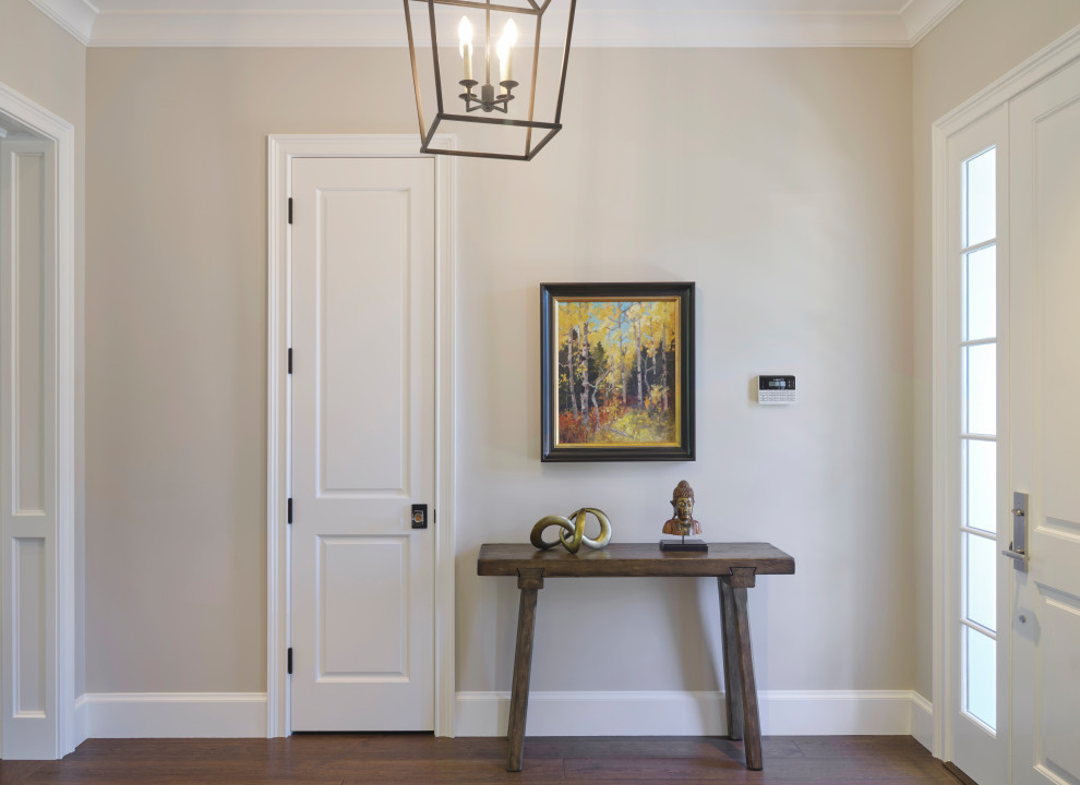 Ejemplo de puerta principal de estilo de casa de campo de tamaño medio con paredes grises, suelo de madera en tonos medios, puerta simple, puerta blanca y suelo marrón