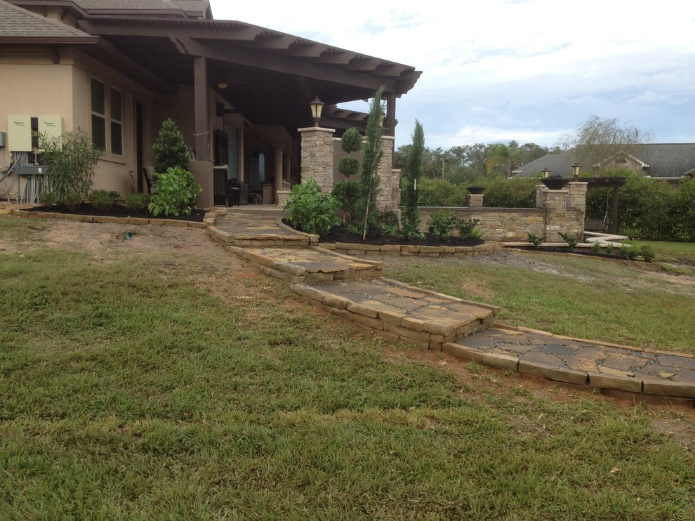 Photo of an expansive country backyard full sun garden for summer in Houston with a container garden and natural stone pavers.