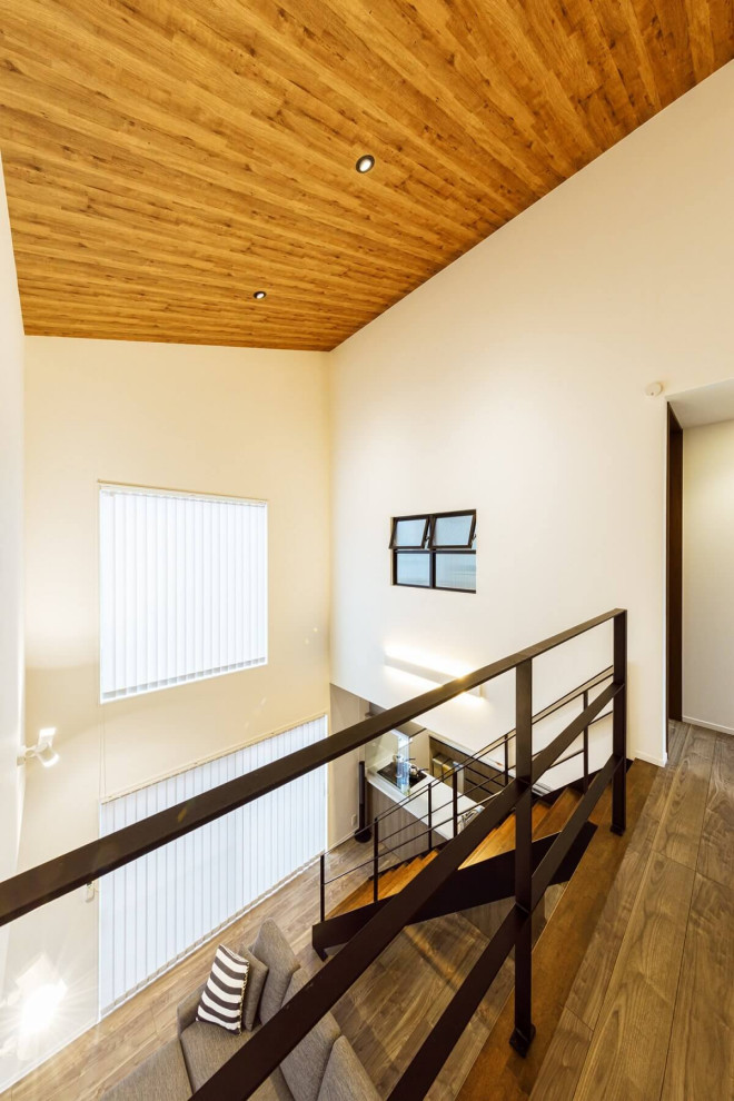 На фото: коридор среднего размера в стиле лофт с белыми стенами, паркетным полом среднего тона, коричневым полом, потолком с обоями и обоями на стенах