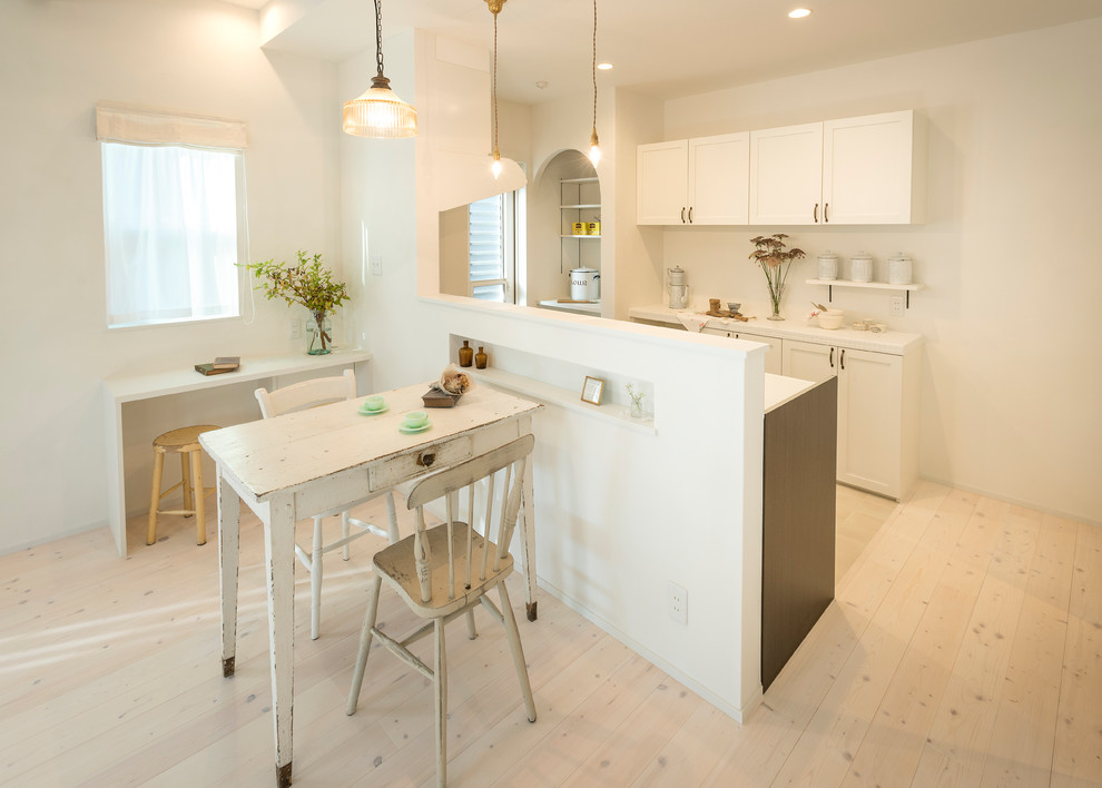 Photo of a scandinavian galley open plan kitchen in Nagoya with recessed-panel cabinets, white cabinets, white splashback, painted wood floors, with island and white floor.