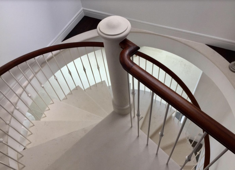 Example of a small trendy limestone spiral metal railing staircase design in Other with limestone risers