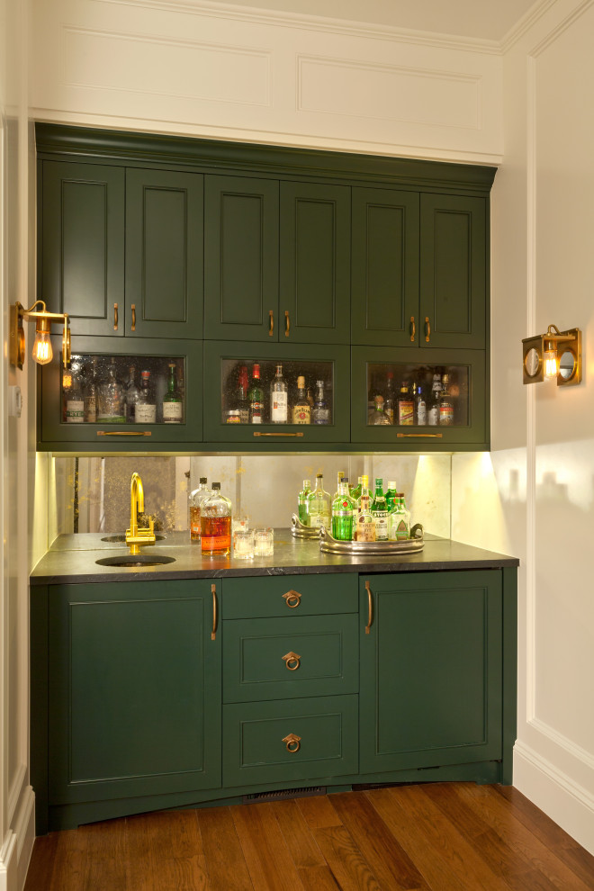 Design ideas for a small classic single-wall wet bar in Denver with a submerged sink, beaded cabinets, green cabinets, marble worktops, glass sheet splashback, light hardwood flooring, brown floors and black worktops.