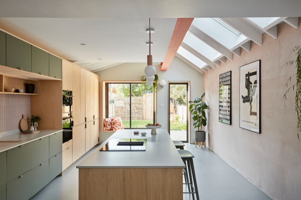 Photo of a mid-sized contemporary single-wall eat-in kitchen in London with flat-panel cabinets, pink splashback, black appliances, with island, grey floor, an integrated sink, light wood cabinets, terrazzo benchtops, ceramic splashback, linoleum floors, white benchtop and exposed beam.