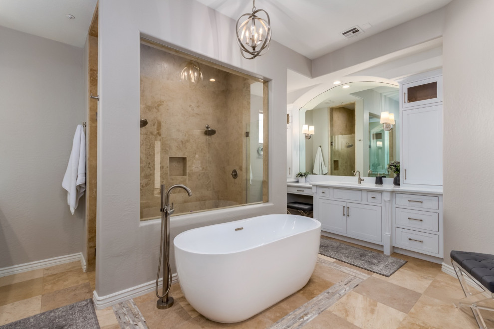 Example of a large transitional master travertine floor and beige floor freestanding bathtub design in Phoenix with beaded inset cabinets, white cabinets, quartz countertops and white countertops