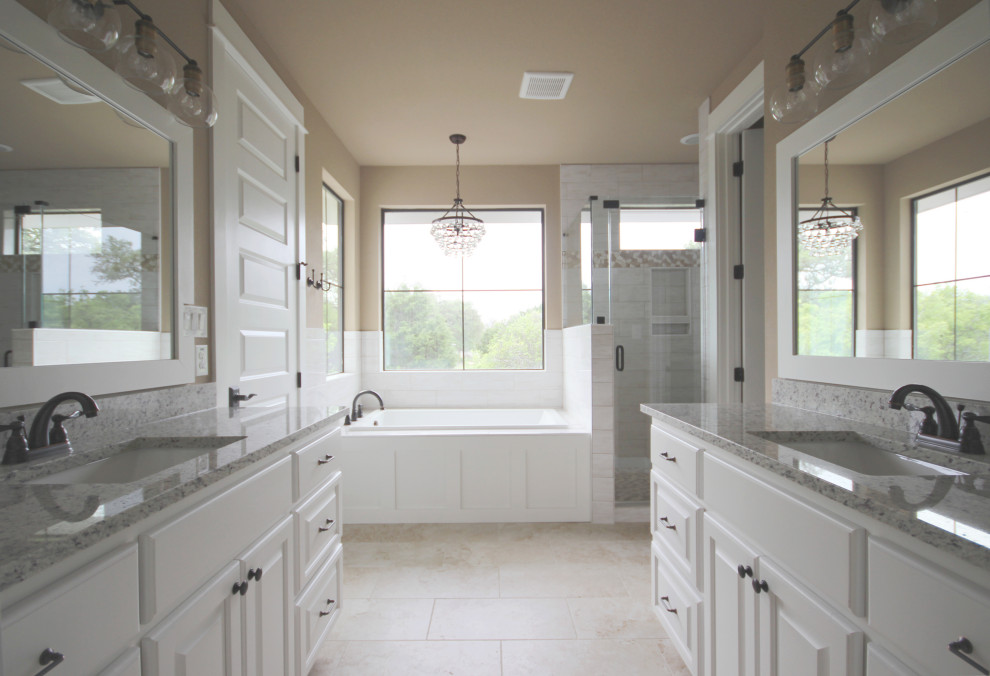 Inspiration for a country bathroom in Austin with white cabinets, a drop-in tub, a corner shower, an undermount sink, granite benchtops, beige floor, a hinged shower door, grey benchtops, a double vanity and a built-in vanity.