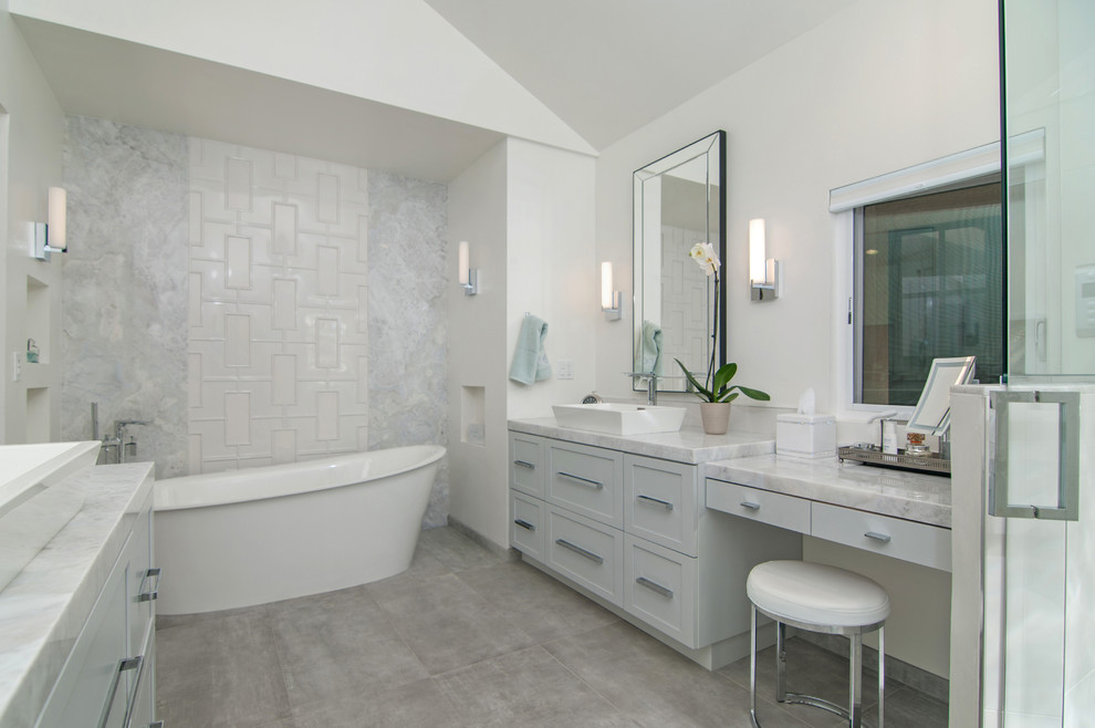 Large transitional master bathroom in San Diego with shaker cabinets, grey cabinets, a freestanding tub, white tile, white walls, porcelain floors, a vessel sink, marble benchtops, grey floor, a corner shower, a one-piece toilet, porcelain tile and a hinged shower door.