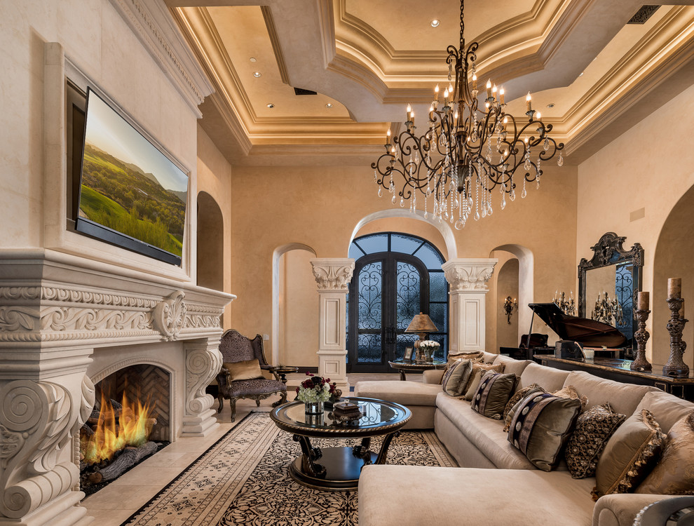 Inspiration for an expansive country open concept living room in Phoenix with a music area, beige walls, marble floors, a standard fireplace, a stone fireplace surround, a wall-mounted tv, beige floor and coffered.