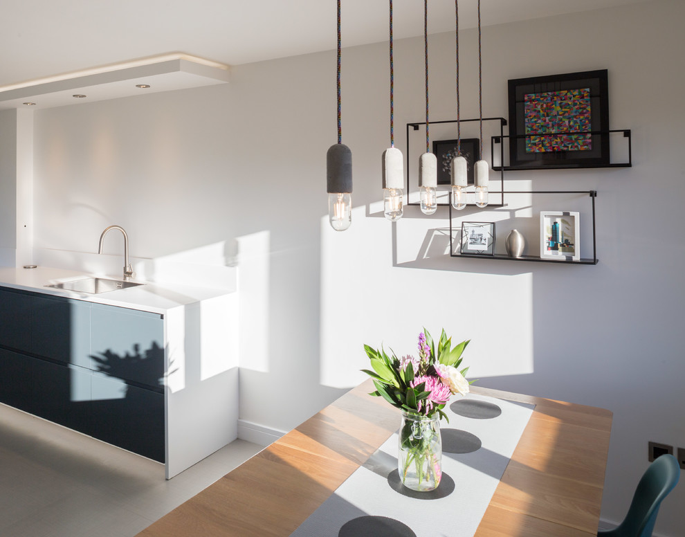 This is an example of a small contemporary open plan dining in Cambridgeshire with white walls, vinyl floors and grey floor.