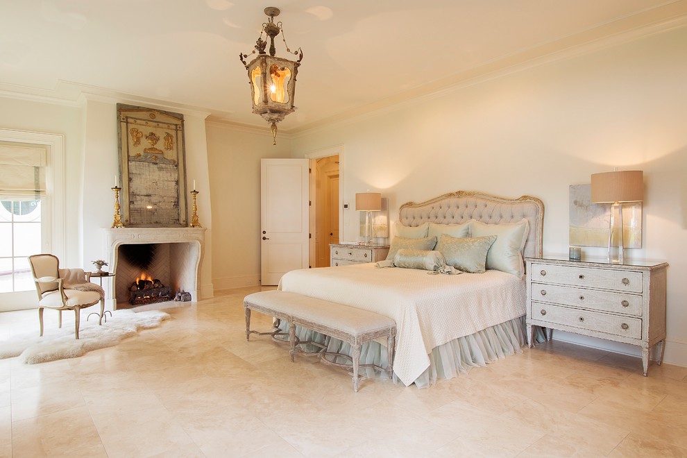 Inspiration for a traditional bedroom in New Orleans with white walls, a standard fireplace and beige floor.
