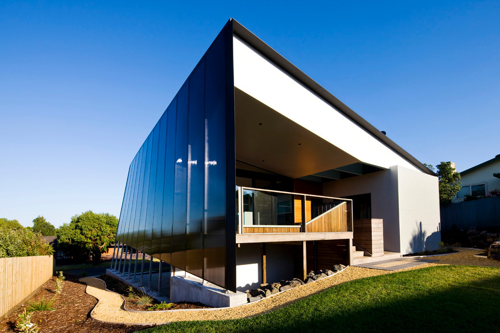 Photo of a small contemporary two-storey black exterior in Melbourne with metal siding and a shed roof.