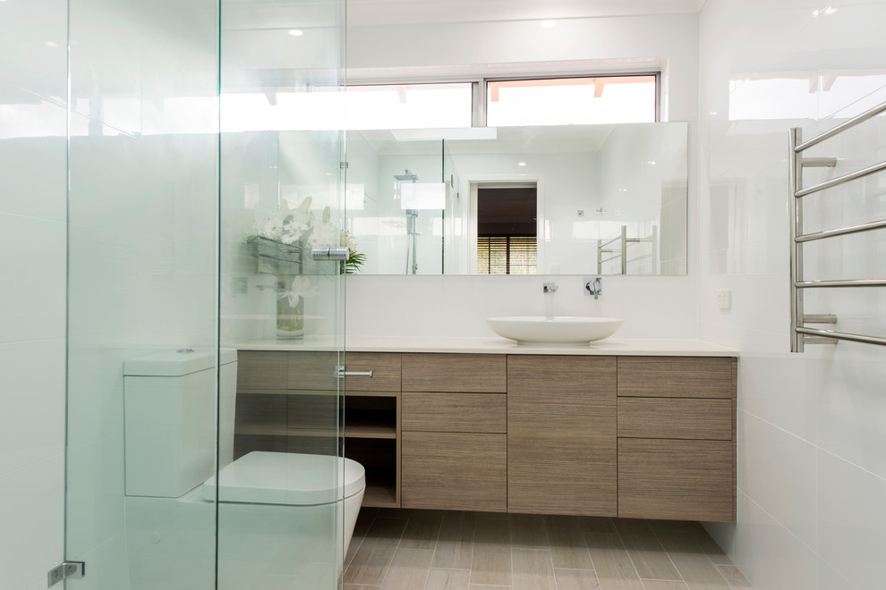 Photo of a mid-sized contemporary master bathroom in Perth with a vessel sink, beaded inset cabinets, dark wood cabinets, engineered quartz benchtops, a curbless shower, a two-piece toilet, black tile, porcelain tile, white walls and porcelain floors.