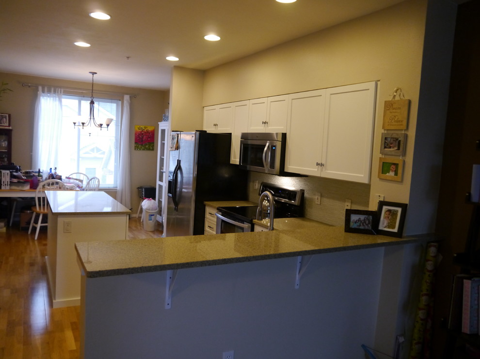 Eat-in kitchen - transitional eat-in kitchen idea in Seattle with an undermount sink, shaker cabinets, white cabinets, granite countertops, glass tile backsplash, stainless steel appliances and an island