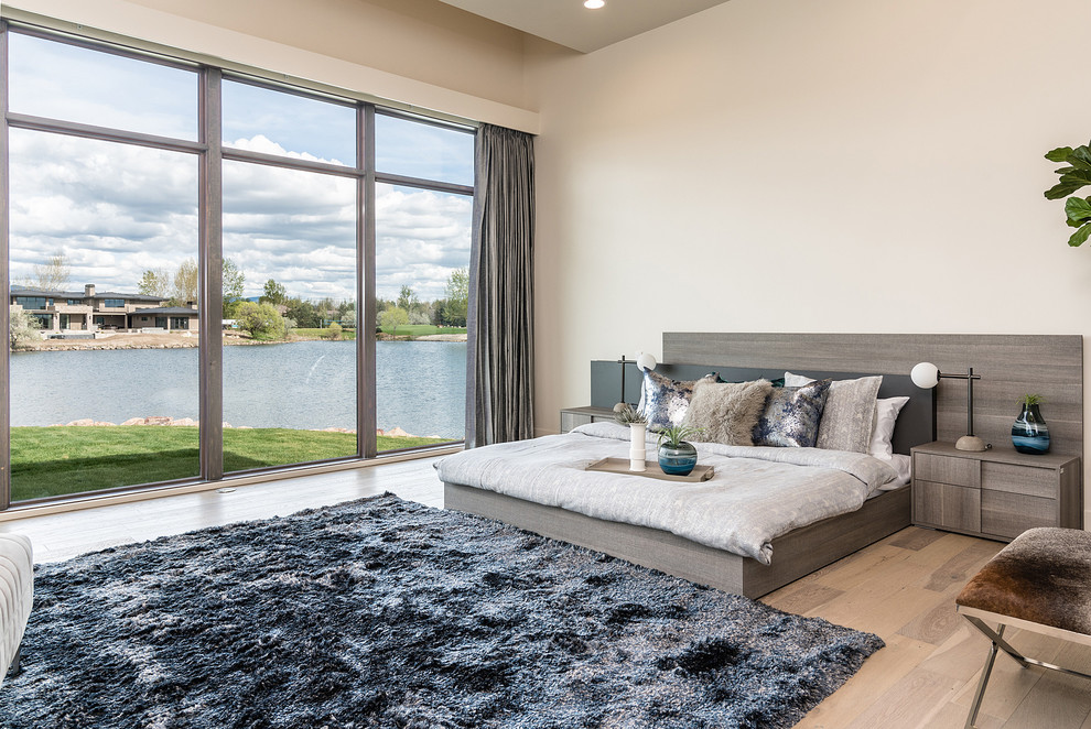 Contemporary master bedroom in Boise with white walls, light hardwood floors and beige floor.