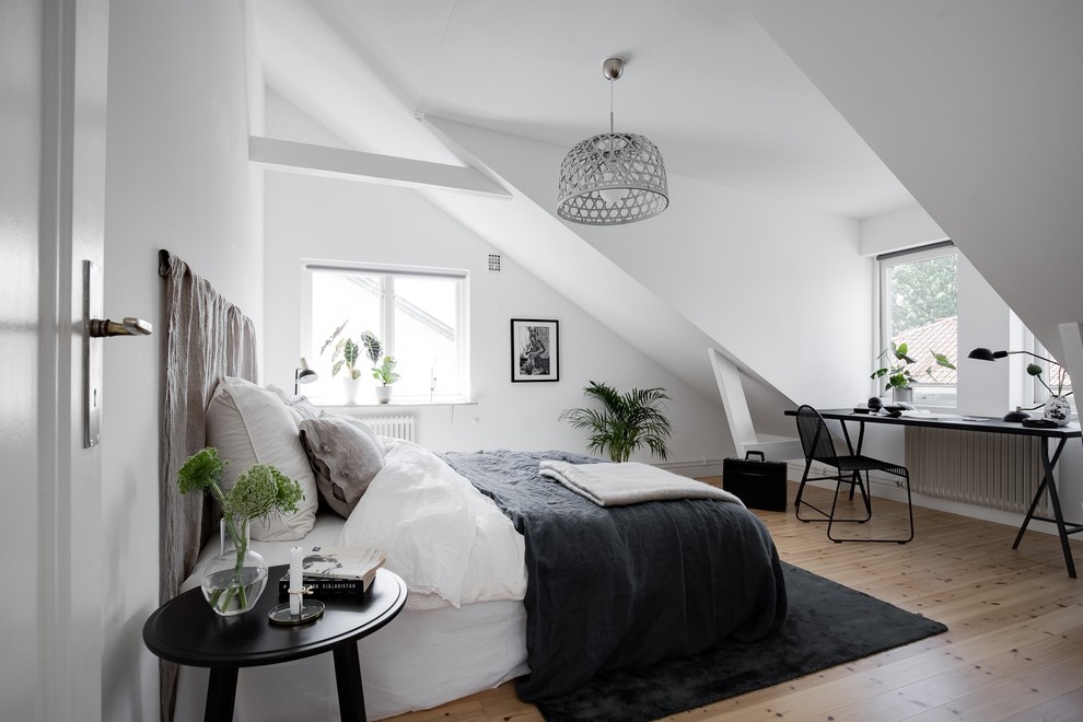 Inspiration for a mid-sized scandinavian guest bedroom in Gothenburg with white walls, light hardwood floors and beige floor.