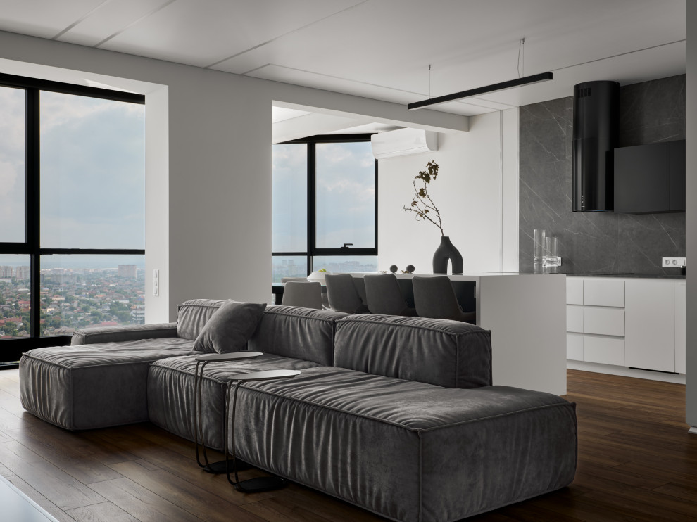 Стильный дизайн: большая гостиная комната в белых тонах с отделкой деревом в современном стиле с серыми стенами, полом из ламината, телевизором на стене и зоной отдыха - последний тренд