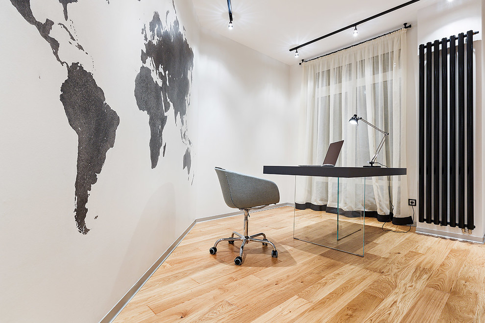 Mittelgroßes Arbeitszimmer mit Arbeitsplatz, weißer Wandfarbe, braunem Holzboden und freistehendem Schreibtisch in Jekaterinburg