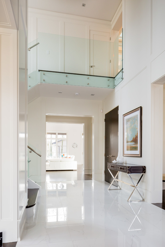 Large contemporary foyer in Toronto with white walls, marble floors, a single front door and a dark wood front door.