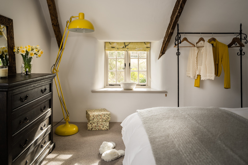 Photo of a mid-sized scandinavian master bedroom in Devon with white walls and carpet.