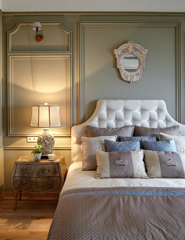 Foto de dormitorio principal de tamaño medio sin chimenea con paredes verdes y suelo de madera clara