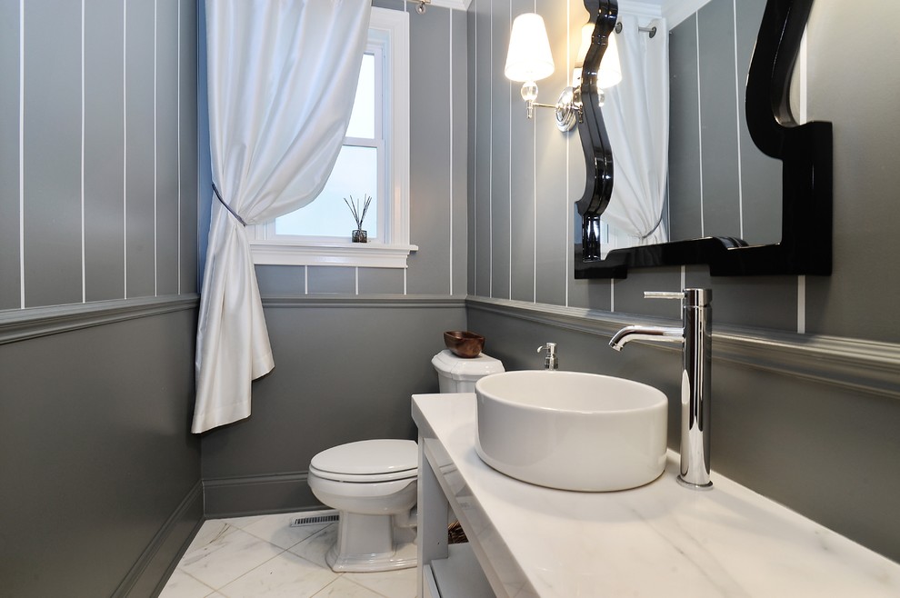 Photo of a large transitional powder room in Chicago with a vessel sink, open cabinets, white cabinets, marble benchtops, a two-piece toilet, white tile, grey walls, marble floors and white benchtops.