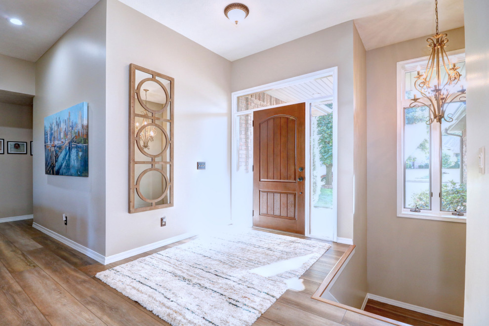 Inspiration for a transitional vinyl floor single front door remodel with gray walls and a brown front door