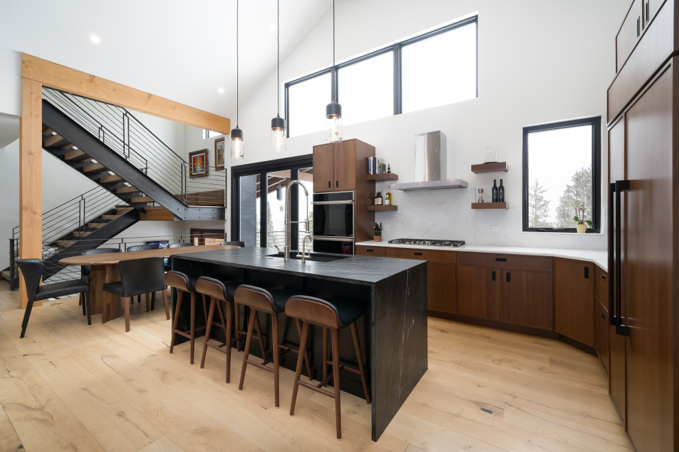 This is an example of a medium sized industrial l-shaped open plan kitchen in Denver with shaker cabinets, medium wood cabinets, marble worktops, integrated appliances, light hardwood flooring, an island, brown floors and multicoloured worktops.