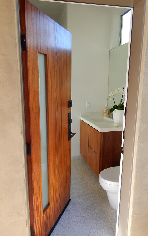 This is an example of a mid-sized midcentury 3/4 bathroom in Los Angeles with a console sink, medium wood cabinets, a two-piece toilet, white tile, white walls and ceramic floors.