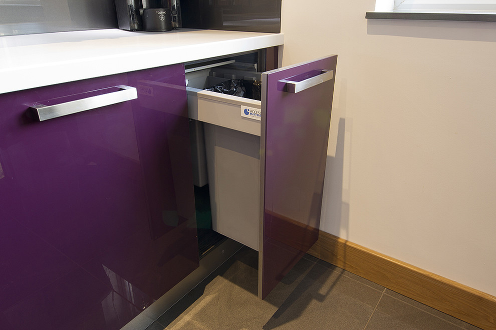 Design ideas for a mid-sized contemporary l-shaped open plan kitchen in Essex with an integrated sink, flat-panel cabinets, purple cabinets, concrete benchtops, metallic splashback, glass sheet splashback, stainless steel appliances, porcelain floors and grey floor.