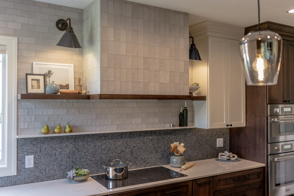 Example of a mid-sized transitional l-shaped medium tone wood floor and brown floor eat-in kitchen design with an undermount sink, recessed-panel cabinets, dark wood cabinets, quartz countertops, blue backsplash, mosaic tile backsplash, stainless steel appliances, an island and white countertops