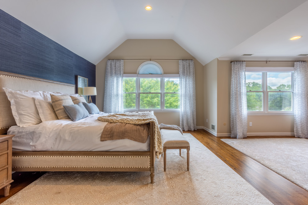 Modelo de dormitorio principal, abovedado y beige minimalista grande sin chimenea con paredes azules, suelo de madera clara, suelo beige y papel pintado