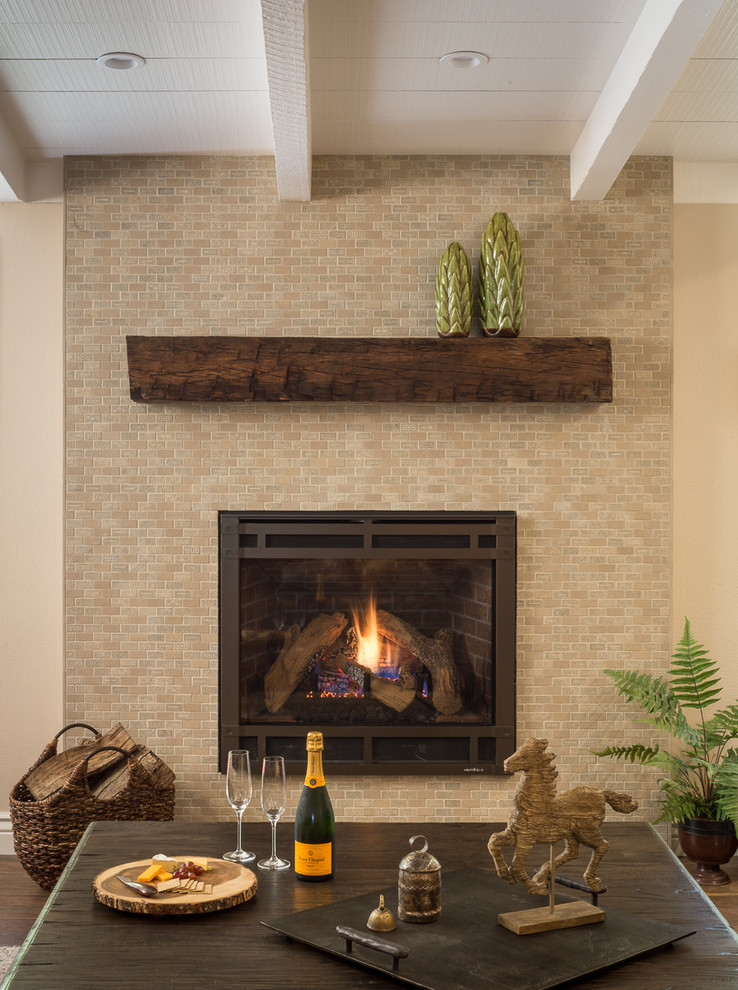 This is an example of a mediterranean living room in San Francisco with beige walls, porcelain floors, a hanging fireplace, a brick fireplace surround and brown floor.
