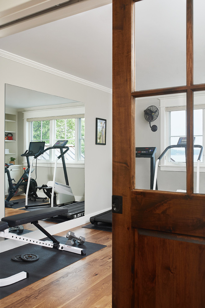 Photo of a small beach style home weight room in Grand Rapids with grey walls, medium hardwood floors and brown floor.