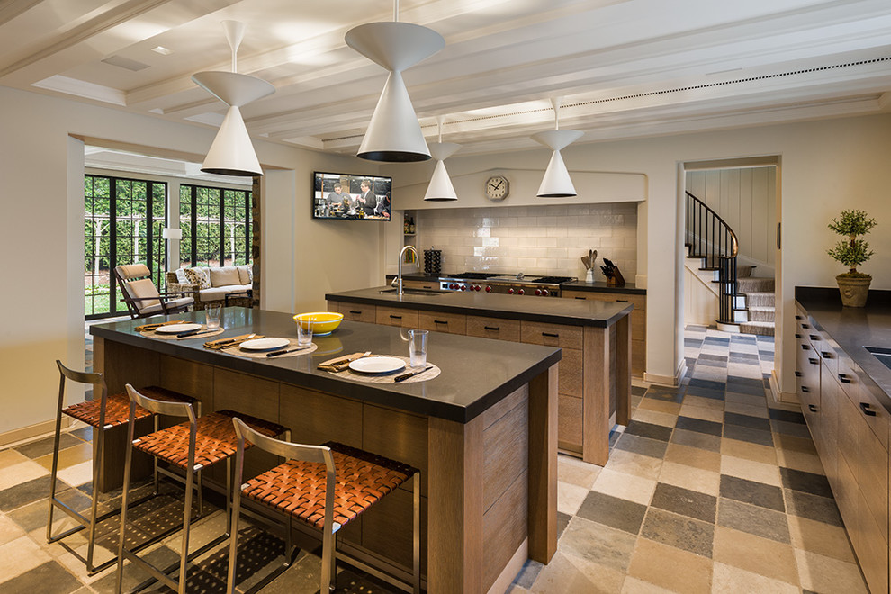 This is an example of a large transitional l-shaped eat-in kitchen in Philadelphia with an undermount sink, flat-panel cabinets, light wood cabinets, limestone benchtops, ceramic splashback, stainless steel appliances, travertine floors and multiple islands.