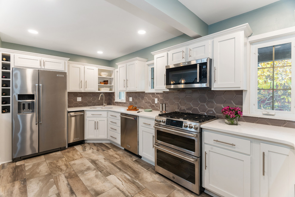 Small transitional u-shaped porcelain tile and beige floor kitchen pantry photo with a drop-in sink, beige backsplash, ceramic backsplash, white countertops, recessed-panel cabinets, white cabinets, stainless steel appliances and quartz countertops