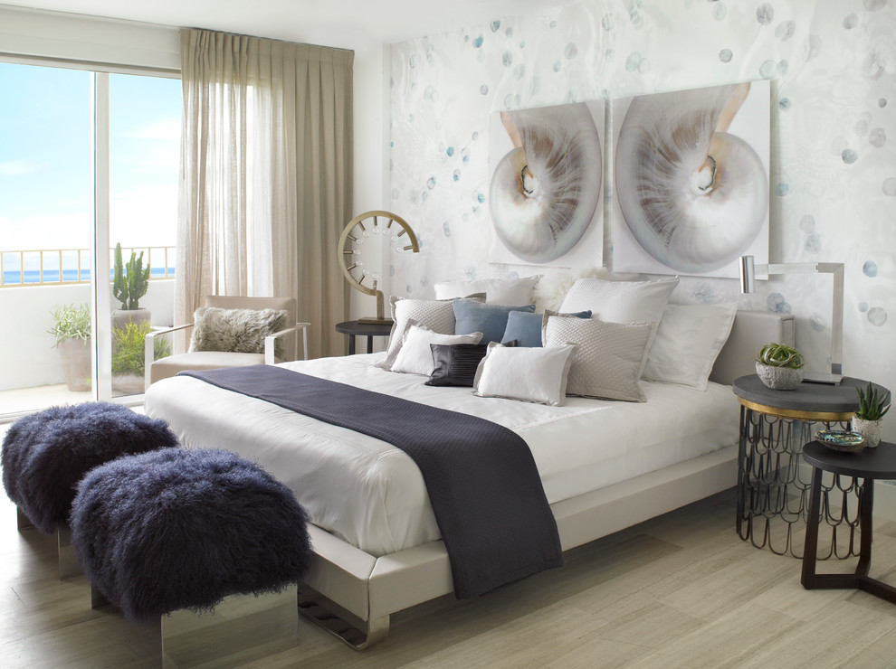 Design ideas for a beach style bedroom in Miami with white walls and light hardwood floors.