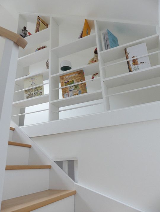 Источник вдохновения для домашнего уюта: п-образная лестница с деревянными ступенями, крашенными деревянными подступенками, деревянными перилами и кладовкой или шкафом под ней