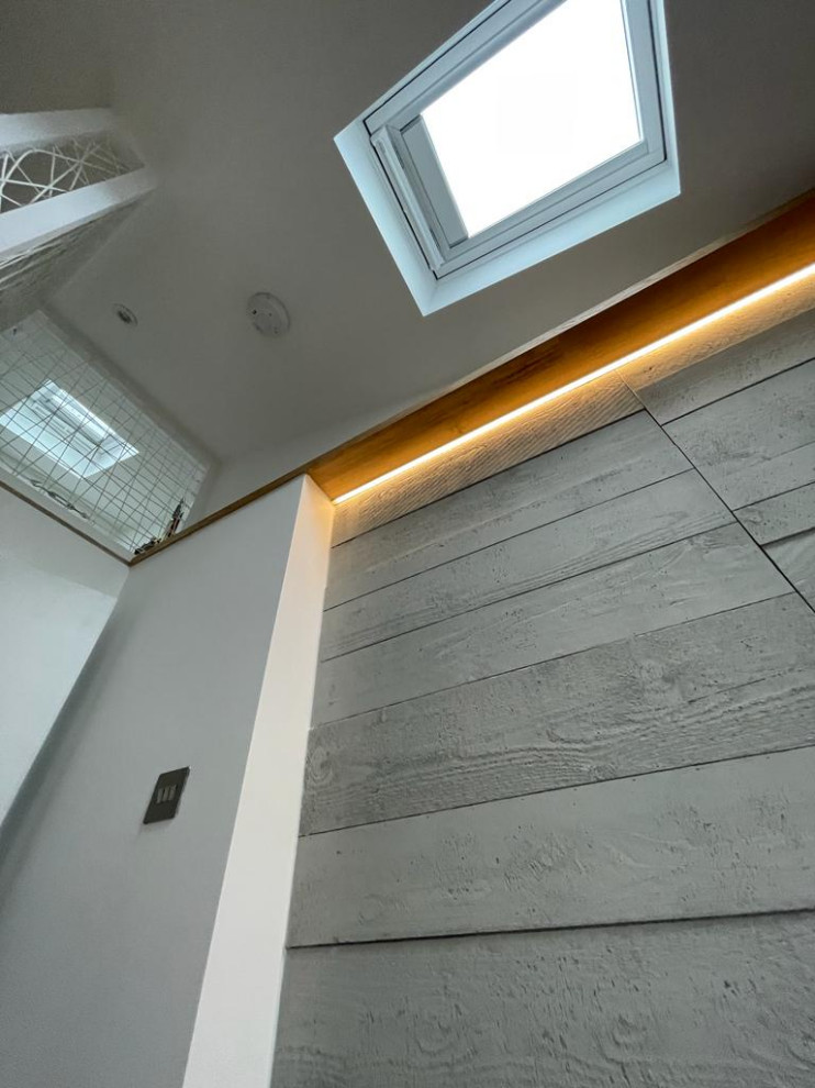 Immagine di una camera da letto stile loft contemporanea con pareti bianche, parquet chiaro, soffitto a volta e pannellatura