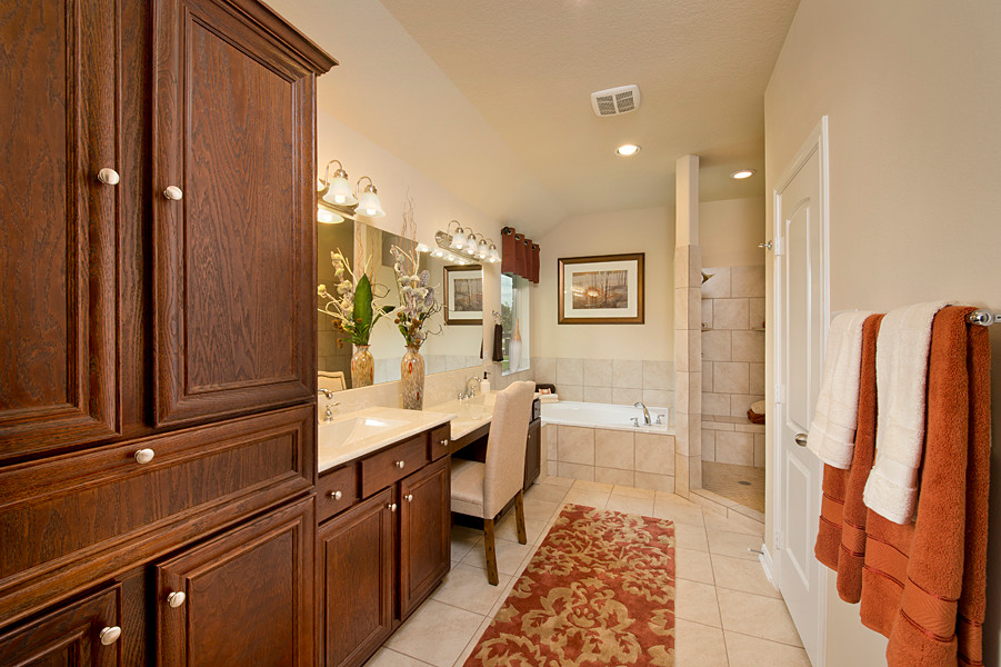 Photo of a mid-sized traditional master bathroom in Houston with beaded inset cabinets, dark wood cabinets, a drop-in tub, a corner shower, a two-piece toilet, beige tile, porcelain tile, beige walls, porcelain floors, a drop-in sink, engineered quartz benchtops, beige floor, an open shower and beige benchtops.