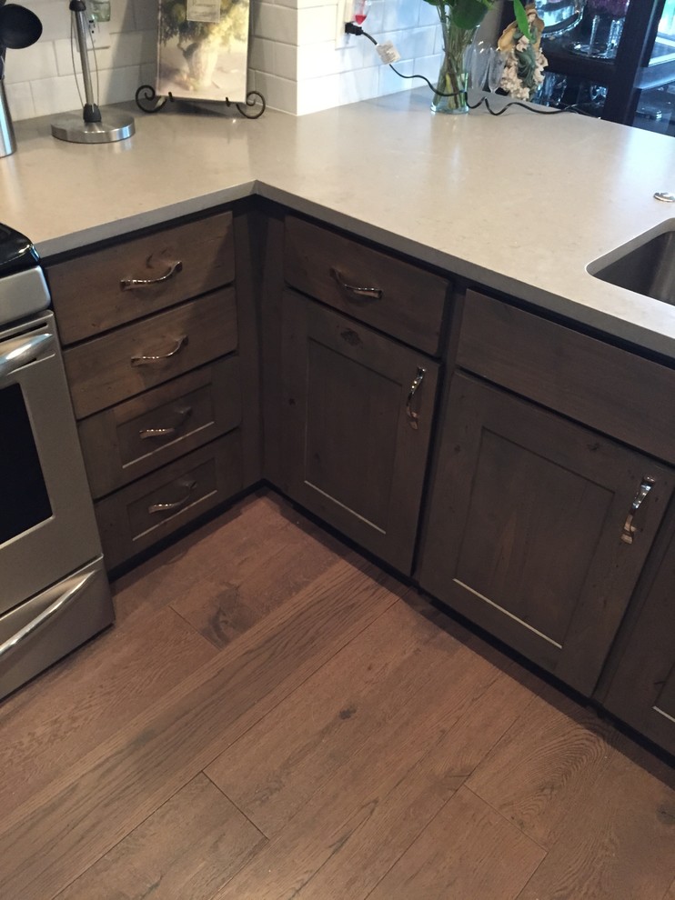 Inspiration for a large country u-shaped eat-in kitchen in Denver with an undermount sink, shaker cabinets, medium wood cabinets, quartzite benchtops, white splashback, ceramic splashback, stainless steel appliances, linoleum floors and a peninsula.